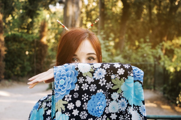 woman-hiding-face-behind-kimono-sleeve_23-2147670168